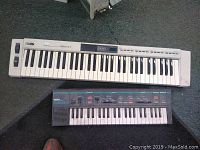 Both keyboards shown side by side on the floor to identify the lot contents.