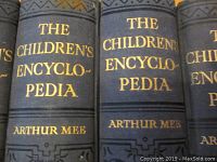 Close-up of the spines of three volumes showing the title 'THE CHILDREN'S ENCYCLOPEDIA' and author 'ARTHUR MEE' in gold lettering on a dark cover.