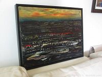 Full view of framed painting leaning against wall on sofa