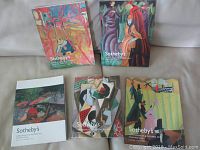 Five Sotheby's Impressionist and Modern Art catalogues with colorful covers displayed on a table.