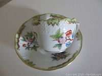 Top view of the cup sitting on the saucer showing floral pattern and gold trim.