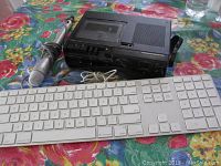 Photo of the three items together: Marantz cassette recorder, Shure microphone, and Apple keyboard on a floral tablecloth