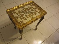 Full view of small ornate table with scalloped edges and floral top