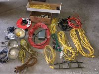 Overview of all electrical cords, extension cords, drop light cages, metal reflector lamps, and wire spool