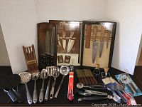 Wide view showing multiple kitchen knife sets with wooden block, utensils, and sharpening stone