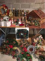 Photo showing a large nativity creche with wooden stable, nativity figurines including wise men and holy family, assorted Christmas figurines, and wreaths on table