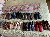 All shoes arranged on bed with organizer on top, showing 15 pairs of women's shoes in various styles and colors.