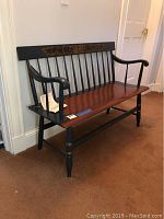 Front view of spindle-back bench showing black frame and brown seat