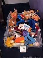 Photo shows a plastic bin filled with various Disney character plush toys including Mickey Mouse, Winnie the Pooh, Eeyore, Donald Duck, a reindeer, and more.