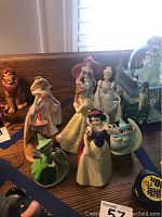 Photo of all princess figurines and fairy godmothers displayed on wooden surface near window, showing size, color, and details