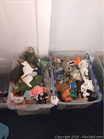 Two plastic bins filled with assorted TY Beanie Babies plush toys in various animal forms and colors.