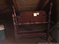 Twin bed wooden headboard showing full view, dark polished wood with turned posts and finials