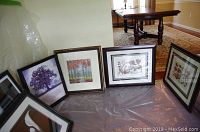 Four framed nature-themed prints arranged on floor including trees and botanical images