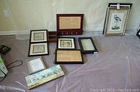 Set of framed wall art displayed on floor against wall showing various prints and bulletin boards, some with mounting hardware and key hooks.