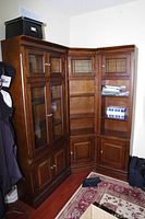 Full view of three-part corner cabinet with glass and wood doors arranged in L shape