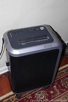 Front view of Fellows S8 99Ci paper shredder showing black and grey casing and wheels.