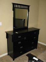 Full view of black dresser with attached mirror showing overall appearance and condition.