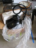 Photo showing the lantern base with curved mounting arm and packaging material