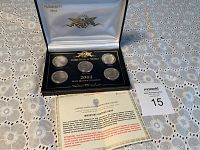 Five 2004 US State Quarters in a black presentation case with white satin lid lining and certificate.