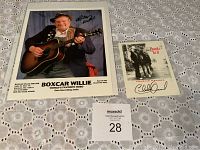 Autographed pictures of Boxcar Willie and Charlie Daniels displayed on a lace tablecloth.