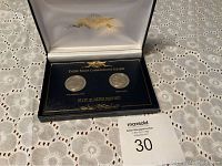 Opened presentation case displaying two Pennsylvania state quarters in protective capsules with dark blue insert and gold lettering.