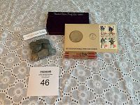 Photo showing 1987 Proof Set case, 1975 Bicentennial First Day Cover envelope with stamps, bag of No Date Buffalo Nickels, and roll of 194x pennies on lace tablecloth.