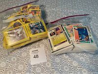 Two bags of baseball cards from 1991 and 1992 placed on a lace cloth surface, cards visible through plastic bags.
