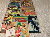 Top-down view of nine comic books spread out, showing various colorful covers including Rogger Rabbit Toontown and Iron Man.