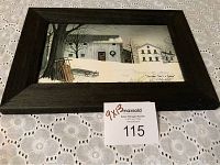Framed winter scene artwork showing two buildings, sled, tree, and wreath in snow, by Billy Jacobs titled 'Christmas Times A Coming'.