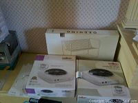 Photo showing two Salton portable cooking range boxes and one IKEA dish rack box stacked together.
