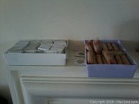 Two plastic trays side by side containing sleeved coins in coin flips and wrapped penny rolls