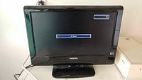 Photo of 18 inch Philips TV powered on with 'No Signal' displayed on screen, showing front view with black bezel and stand.