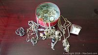 Photo showing the overall contents of the tin and items spread out on a wooden surface.