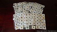 Overview of multiple 2x2 cardboard coin holders spread across a table showing coins and binder sheets