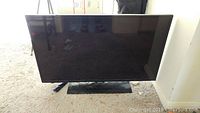Front view of 40 inch Samsung flat screen TV on black stand showing screen and bezel.