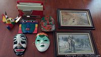Photo shows entire lot including red vintage Admiral radio, five assorted vintage wall masks of various colors and styles, and two framed Robert Taylor prints.