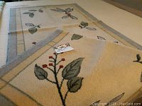 Two close-up photos of the two small area rugs laid out flat, highlighting the floral and insect motifs and border designs.