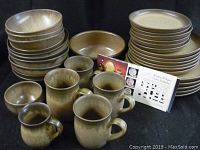 Overview photo of stacked Denby pottery items on black backdrop, showing bowls, mugs, and plates with accompanying brand/style reference card.