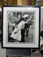 Full view of framed print showing the iconic sailor and nurse kissing on VJ Day in a city setting.