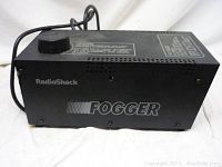 Side view of black RadioShack Fogger fog machine with brand and product name visible.