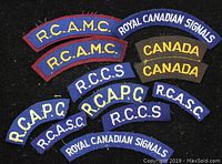 Photo showing 13 vintage military fabric shoulder flashes with Canadian unit insignias arranged on a black background.