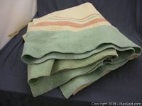 Photo of folded vintage wool blanket showing colors and texture.