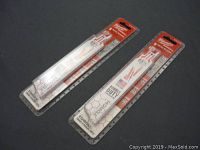 Two sealed packages of Milwaukee Sawzall blades on a black surface, packaging showing the brand and indicating 'Double Duty,' 'Torch Cuts,' and 5 metal blades per pack.