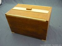Closed view of the vintage wooden trinket box/humidor, showing its rectangular shape and wooden lid with handle.