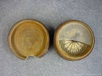 Antique compass in round wooden case with heavily damaged cover, showing the dial inside