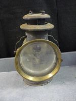 Front view showing rounded glass lens with brass rim and overall wear.