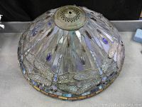 Side view of domed leaded glass shade showing dragonfly motif and brass cap