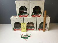 Five boxed woodland critter Christmas buildings stacked with visible front arched windows showing miniature scenes.