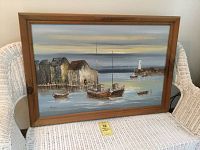 Full view of the signed harbor painting in a natural wood frame, showing boats and buildings on water.