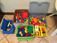 Overview of all building toys stored in five containers: includes Tinker Toys parts, Lego and Duplo blocks, and marble raceway pieces.